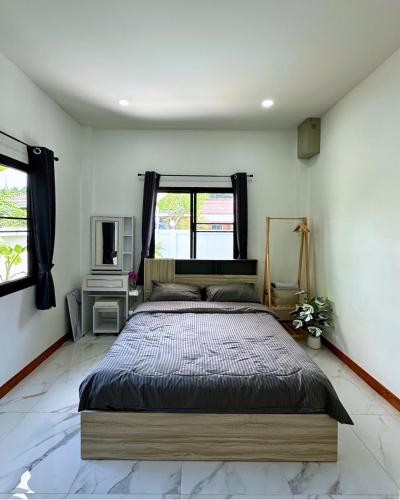 a bedroom with a large bed and a window at PoolvillaLana 3 rooms in Bang Sare