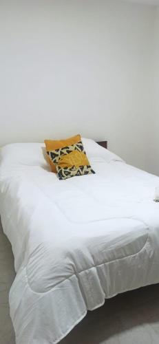 ein weißes Bett mit einem Kissen darüber in der Unterkunft Departamento nuevo cerca de micro centro 5 in San Luis