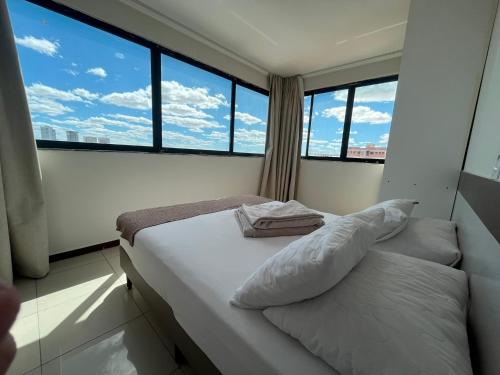 a small bedroom with a bed with a large window at Águas Palace Hotel in Petrolina