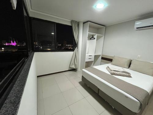 a bedroom with a bed with a view of a city at Águas Palace Hotel in Petrolina