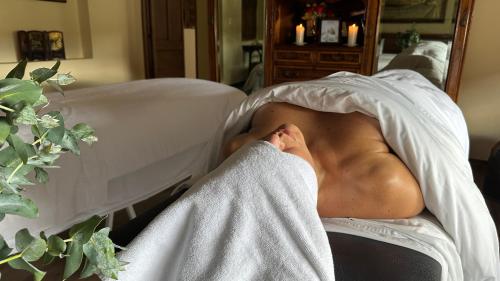 a man laying in a bed under a blanket at Hotel Plazuela de San Agustín - PSA Hotel in Villa de Leyva