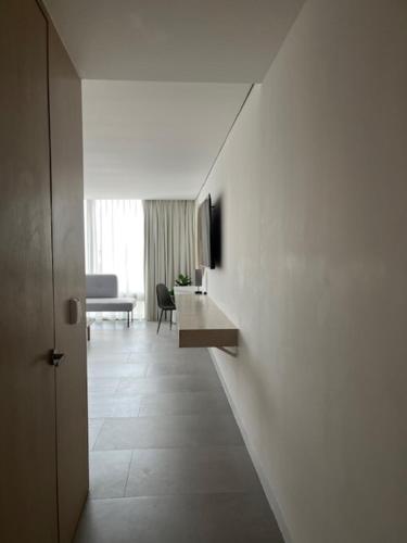 einen Flur, der zu einem Wohnzimmer mit weißen Wänden führt in der Unterkunft Hotel Alcalà Centro in Guadalajara