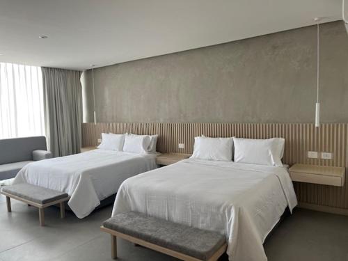 ein Hotelzimmer mit zwei Betten und einer Couch in der Unterkunft Hotel Alcalà Centro in Guadalajara