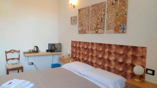 a bedroom with a bed with a brown padded headboard at Villa Liberty B&B in Fano