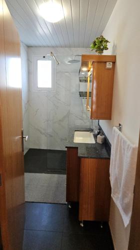 a bathroom with a shower and a sink and a sink at Lower Floor In Flor do Campo - Santana in Santana