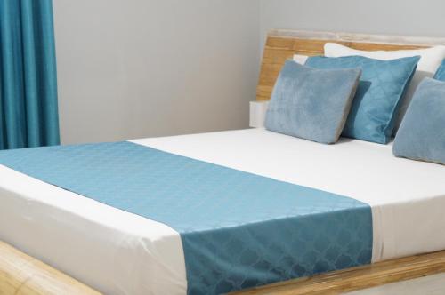 a bedroom with a bed with blue pillows at Ilidia Guest House in Sal Rei