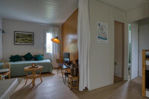 un soggiorno con un letto e un tavolo di Chalet en plein nature, gorges de la Dordogne a Sérandon