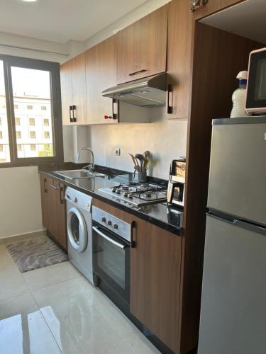a kitchen with a stove and a sink and a refrigerator at Apartment proche gueliz in Marrakech