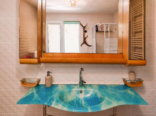 a bathroom with a blue sink and a mirror at Cabana lui Foardă in Motru Sec