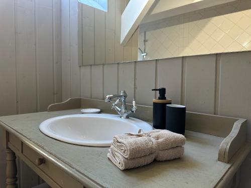 Un lavabo de baño con toallas sobre un mostrador en Beaux-Regards, en Saint Lo