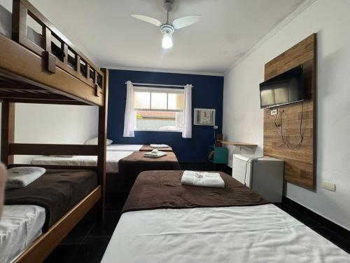 a bedroom with two bunk beds and a window at Pousada Hotel Canto dos Mares in Guarujá