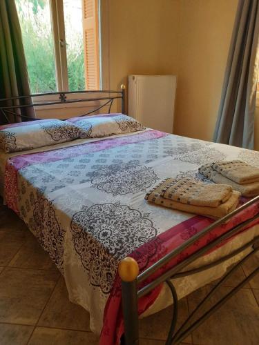 a bedroom with a bed with a bedspread on it at The olive House in Leonidio
