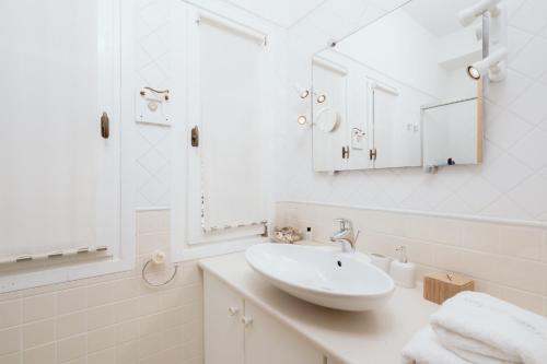 アンドロスにあるVilla Nikiの洗面台と鏡のある白いバスルーム