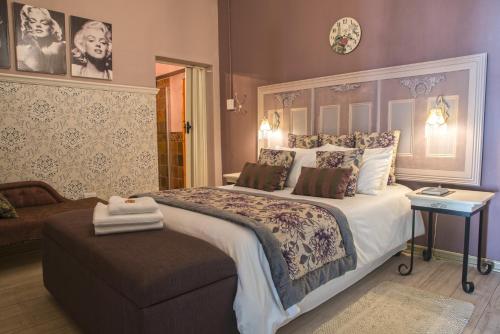 1 dormitorio con 1 cama grande y 1 sofá en Blue Rain Guest House, en Upington