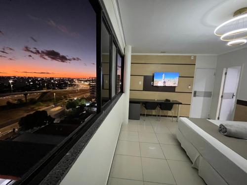 a living room with a couch and a large window at Águas Palace Hotel in Petrolina