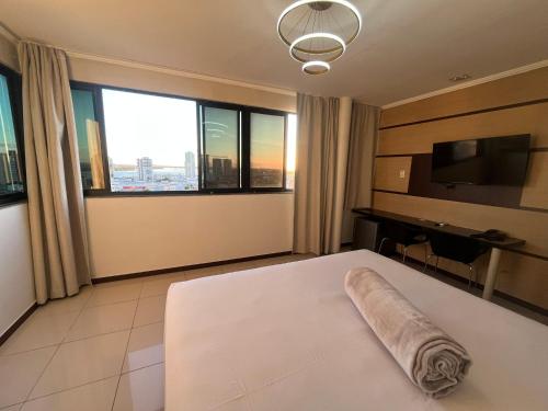 a hotel room with a bed and a large window at Águas Palace Hotel in Petrolina