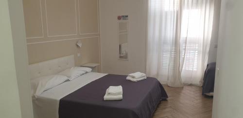 a bedroom with a bed with two towels on it at Le Suite del Lungomare in Taranto