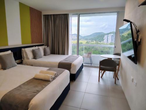 a hotel room with two beds and a large window at MySuyte in Santa Marta