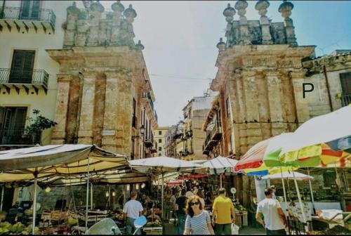巴勒莫Il sole siciliano的一群人带着雨伞在市场里漫步