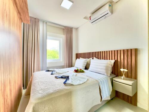 a bedroom with a large bed with a window at Casa Completa com Churrasqueira Wi-Fi e Garagem para 2 Carros a 400m da PRAIA Acomoda 8 Pessoas, 3 suites com Ar-Condicionado in Piçarras