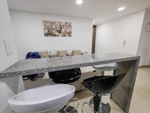 a bathroom with a marble counter and stools at Apartamento moderno frente a la Universidad Santo Tomás WiFi y parqueadero in Tunja
