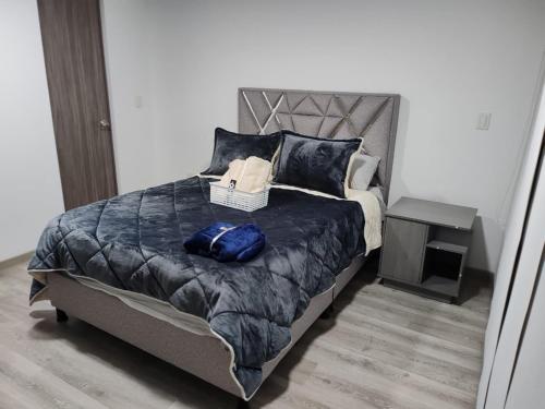 a bedroom with a bed with a blue bag on it at Apartamento moderno frente a la Universidad Santo Tomás WiFi y parqueadero in Tunja