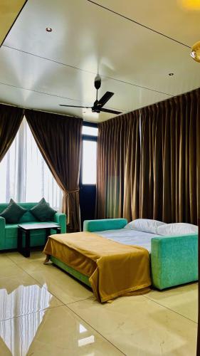 a bedroom with a bed and a couch and curtains at TJ VISTA LIVING in Cochin
