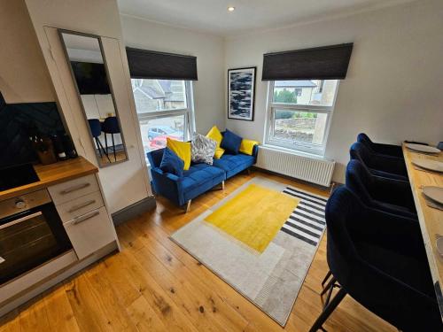 a living room with a blue couch and a tv at CityPad 2BR City Centre Modern Apartment with Parking in Cardiff