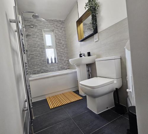 a bathroom with a white toilet and a sink at CityPad 2BR City Centre Modern Apartment with Parking in Cardiff