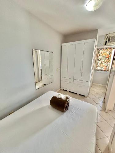 Un dormitorio con una gran cama blanca con una almohada marrón encima. en Ocean903, en Vila Velha