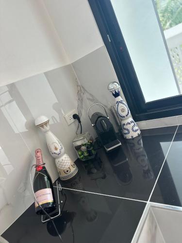 a counter with a bottle of wine and other objects at PoolvillaLana 3 rooms in Bang Sare