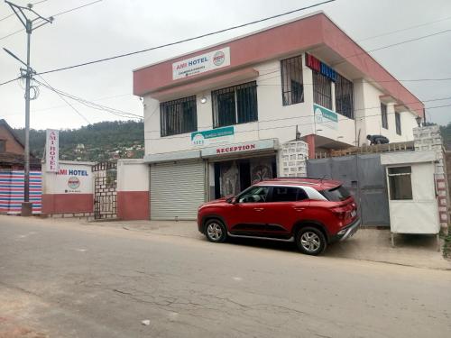 ein rotes Auto, das vor einem Gebäude geparkt ist in der Unterkunft Ami Hotel in Fianarantsoa