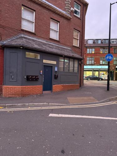 a brick building with a blue door on a street at Sheffield City Centre - Westhill House Apartments in Sheffield