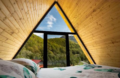 una finestra in una camera con letto e vista di Chalet Carolina a Padeş