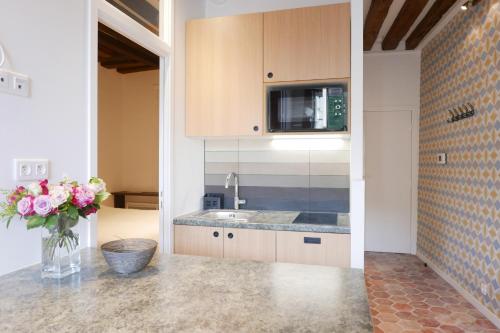 une cuisine avec un comptoir et un vase de fleurs dans l'établissement Apartments Cosy, à Paris