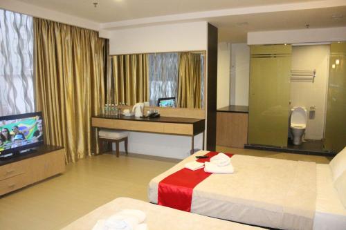 a hotel room with a bed and a television at T Hotel Jalan Tar in Kuala Lumpur