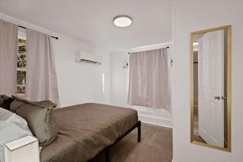 a bedroom with a bed and a mirror and a window at Blue Ox in Pensacola