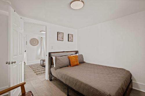 a bedroom with a bed with an orange pillow on it at Blue Ox in Pensacola