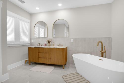 a white bathroom with a tub and two mirrors at Creekside - Custom Luxury in Bay Creek Resort! in Cape Charles