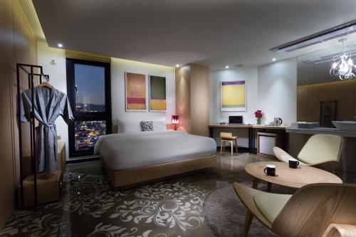 um quarto com uma cama, uma secretária e uma cozinha em Hotel Sienna em Paju