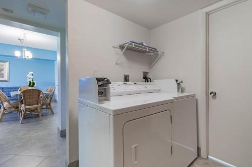 una cucina bianca con piano cottura e una sala da pranzo di Surf Rider Resort a Pompano Beach
