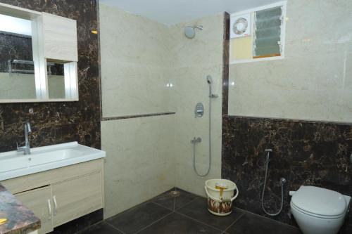a bathroom with a shower and a toilet and a sink at Chettinad Courtyard By Shivalaya Coimbatore in Alāndurai
