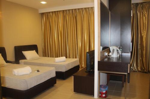 a hotel room with two beds and a television at T Hotel Jalan Tar in Kuala Lumpur