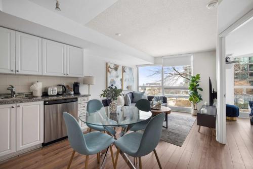 a kitchen and dining room with a glass table and chairs at Stylish 1BR Condo Near Toronto Top Attractions in Toronto