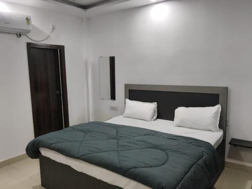 Un dormitorio con una cama grande con una manta verde. en Hotel Shivaay Inn, en Kānpur