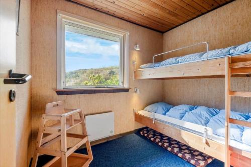 a small room with bunk beds and a window at FAN070-Fano-Nybyvej-58-B in Fanø