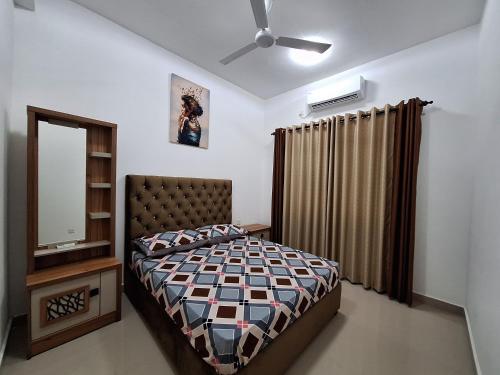 ein Schlafzimmer mit einem Bett und einem Deckenventilator in der Unterkunft Canterbury Golf line Residence - The Luxurious Stay in Gonapola