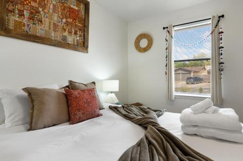 a bedroom with a white bed with pillows and a window at Steps From Balloon Fiesta Park Outdoor Retreat in Albuquerque