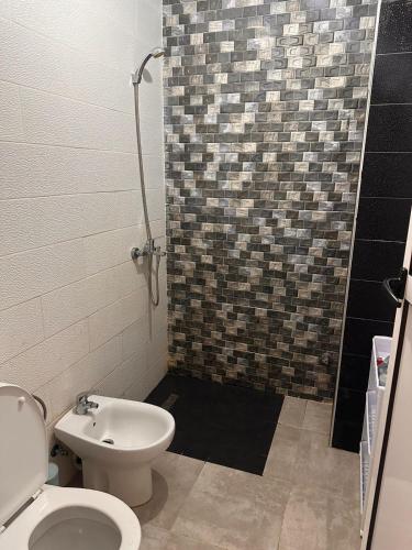 a bathroom with a shower and a toilet and a sink at Appartement azla plage in Oulad Akkou