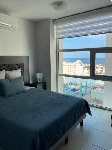 a bedroom with a blue bed and a large window at Sea View 10 Boca Towers in Boca del Río